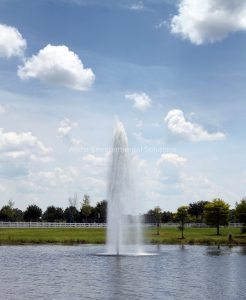 Floating fountain aerator adding oxygen and circulation to a community lake to control odour in the Middle East summer