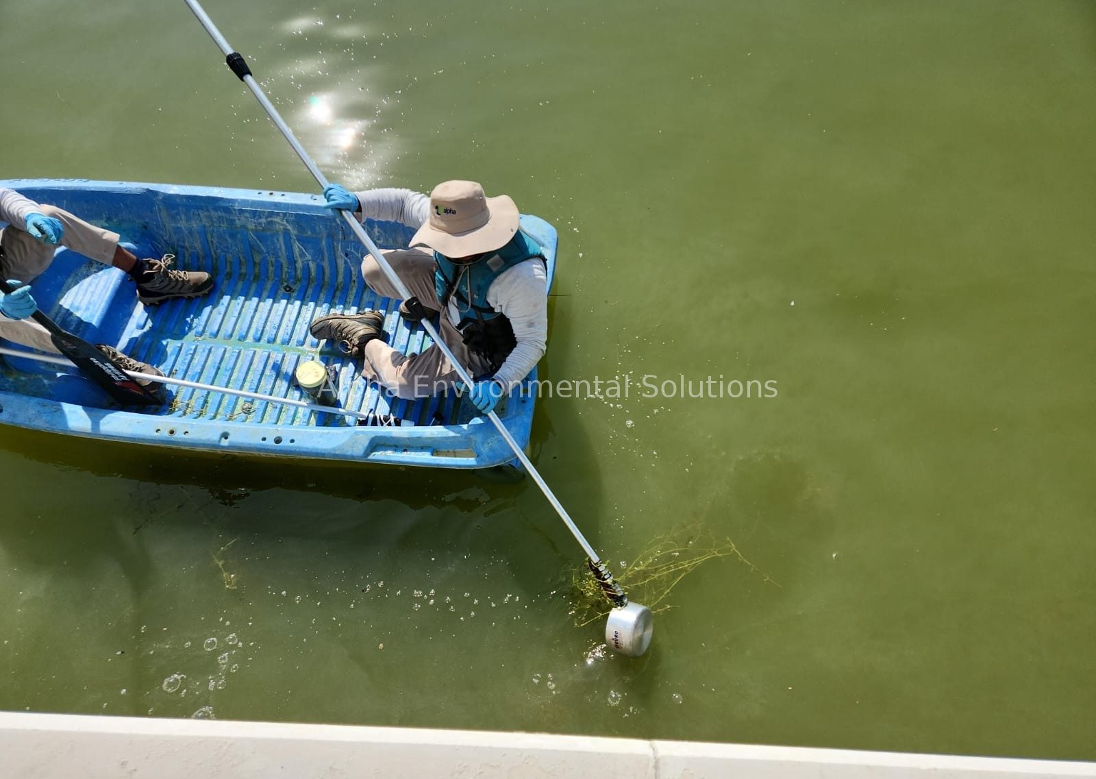 Alpha technicians sampling water quality from a boat on a community lake