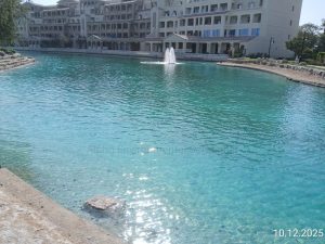 Clear turquoise community lake with a floating fountain after algae control by Alpha Environmental Solutions